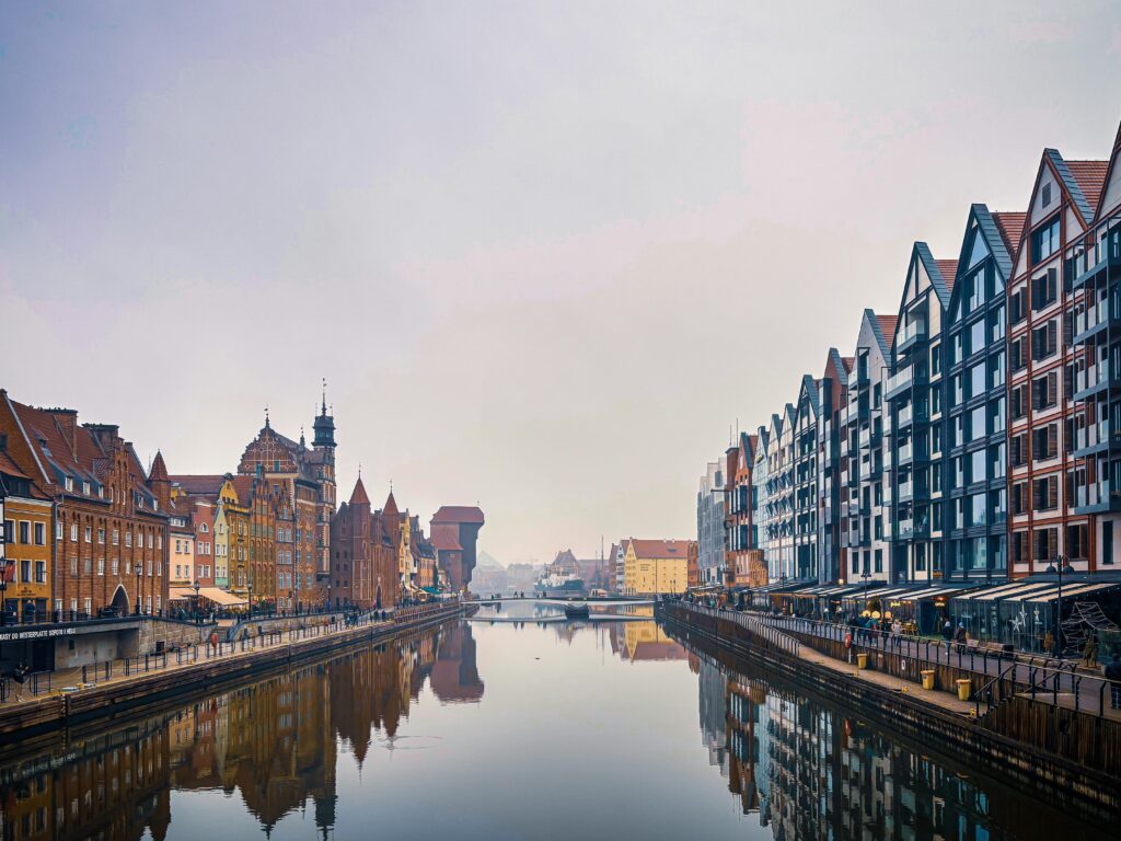 Scenic view of Gdańsk's historic architecture along the Motława River with reflections.